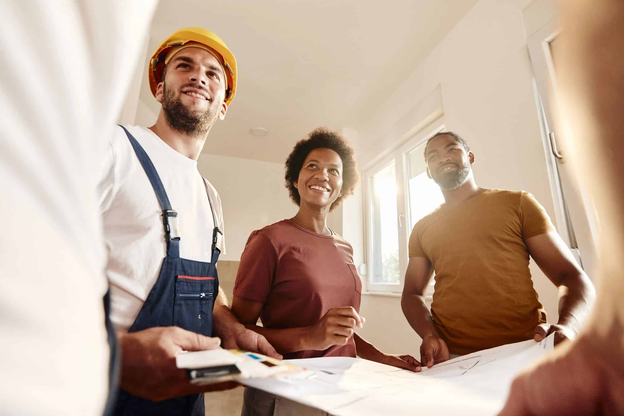 Homeowners reviewing renovation plans with construction professionals