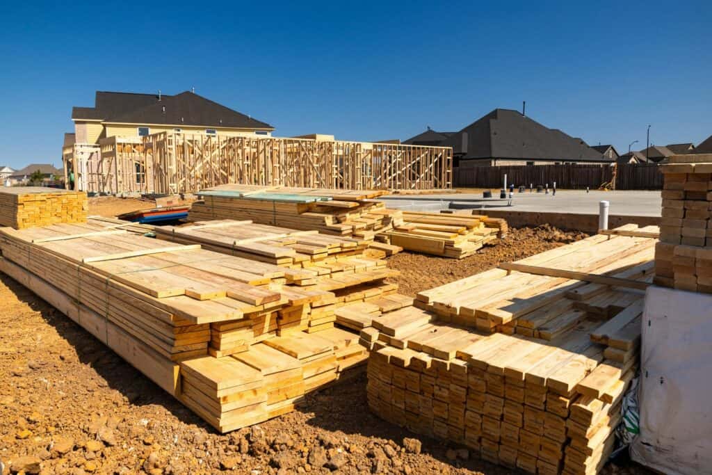 Framing lumber beside a new concrete foundation for a North Texas home
