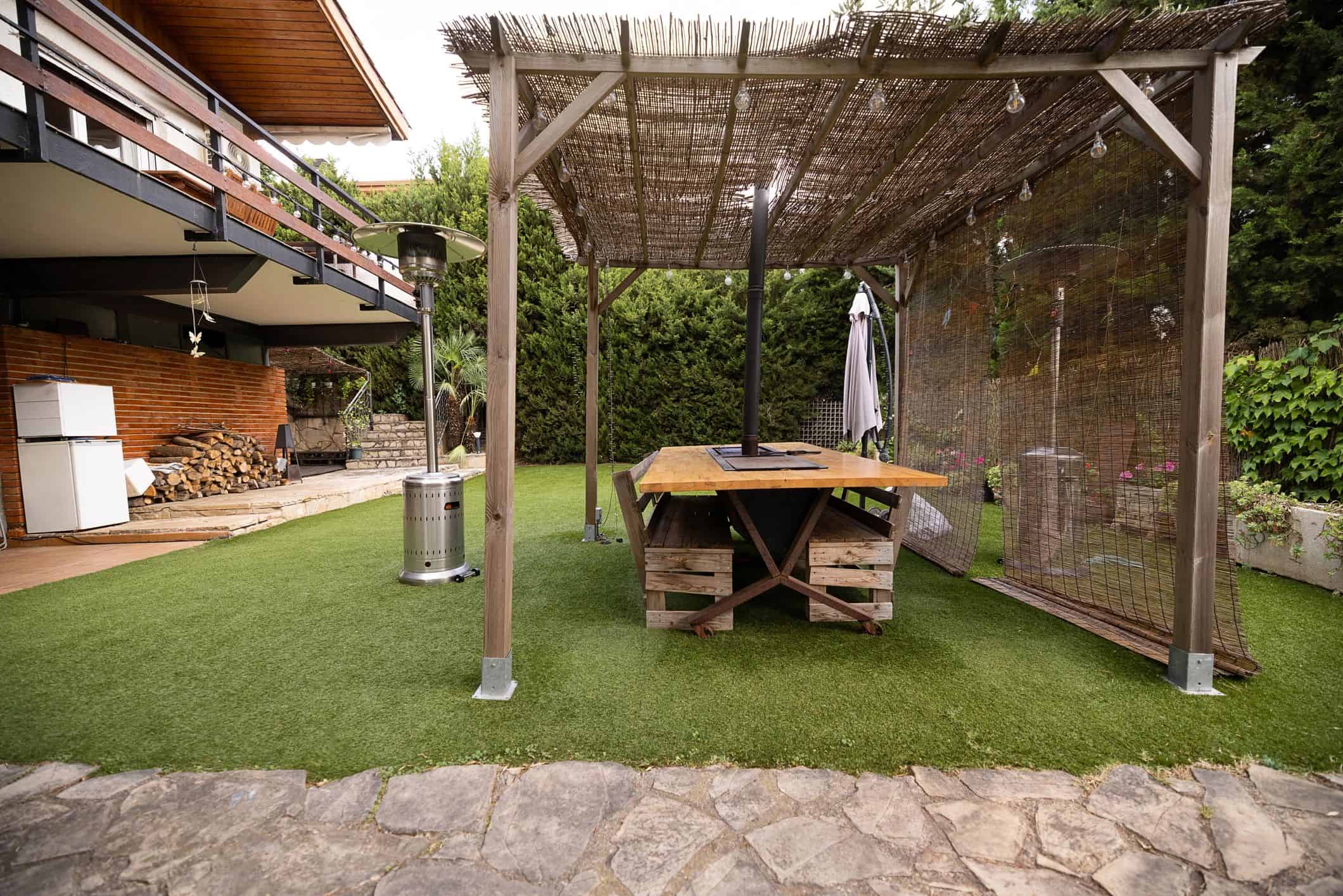 Wooden covered patio with outdoor dining beside a home